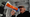 A man yells into a loudspeaker with a "Tax The Rich" sticker on it at a protest.